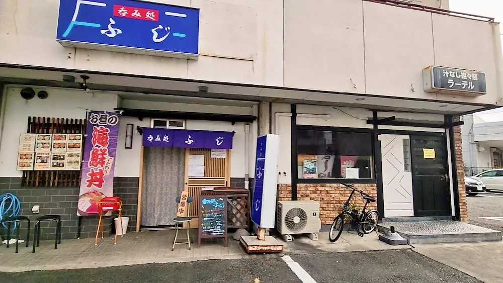 ラーテルの店舗外観。呑み処ふじの近くにある汁なし担々麺の看板が見える飲食店